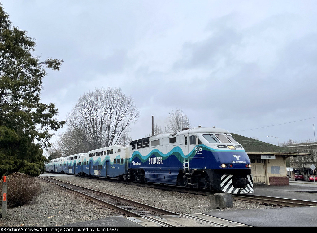 Southbound Sounder Train # 1507, with an F59PHI in the lead, has just departed the Kent Sounder Station and is passing the former Northern Pacific station on the right.